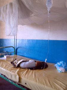 Matimu at the public hospital in Tamatave, shortly after checking in. A bare bed and the I/V is tied to the bed post with another I/V tube.