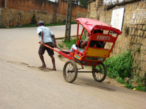A typical "posy-posy" driver struggling barefoot uphill to carry his passengers.