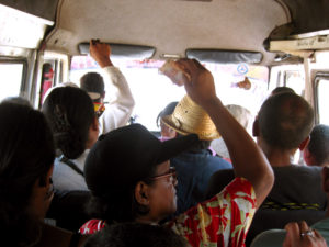 A standard "taxi be" (public transport van) in Madagascar. People are passing their money back to pay the driver... the standard fee is $.15 anywhere along the taxi be route.