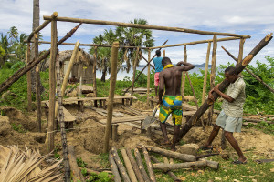 Carefully arranging each supporting post to form the new foundation of our team meeting hut.