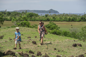Lora carrying David and walking with Matimu to visit with people in another village on Nosy Mitsio.